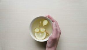 South Korea A hand holding a bowl of water with lemon slices and ginger, perfect for refreshing oneself while travelling in South Korea.
