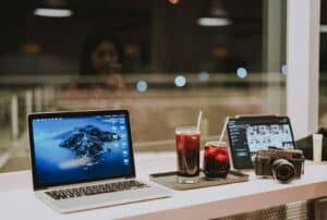 macbook pro beside black iphone 4 on white table